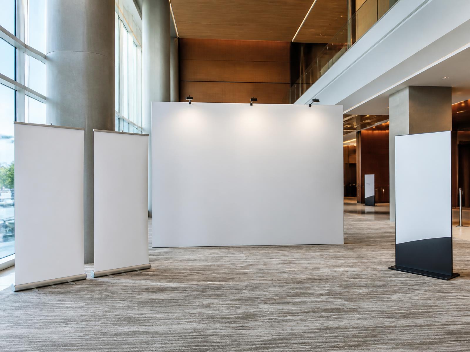Pull-up banners and a media wall set up in a conference foyer